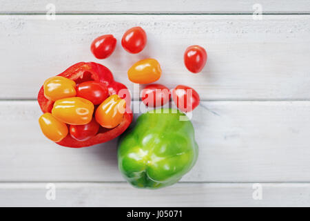 La moitié poivron rouge farci aux tomates cerises accompagnées d'un poivron vert. Banque D'Images