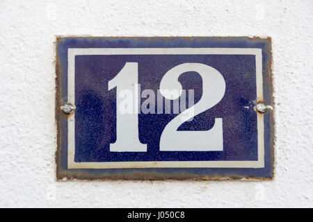 Numéro de maison 12 en blanc sur une plaque métallique bleue Banque D'Images
