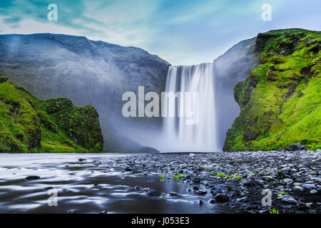 Vue d'exposition longue classique de la célèbre cascade de Skogafoss magnifique crépuscule pendant heure bleue au crépuscule en été, Skogar, au sud de l'Islande Banque D'Images