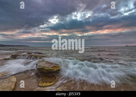 Une longue exposition seascape avec obturateur lent, et les vagues qui s'écoule au coucher du soleil Banque D'Images