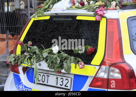 De l'essuie-une police suédoise (Polis) voiture avec fleurs et coeurs dessiné à la main sur le pare-brise en verre de refléter les sentiments de surface suédois concernant la mémoire des victimes du 7 avril 2017 attaque terroriste à l'extérieur de Stockholm Ahlens t-centralen métro stop. Vue de l'intérieur de la station de métro Ahlens. La ville de Stockholm, Suède. 9 avril 2017. Banque D'Images
