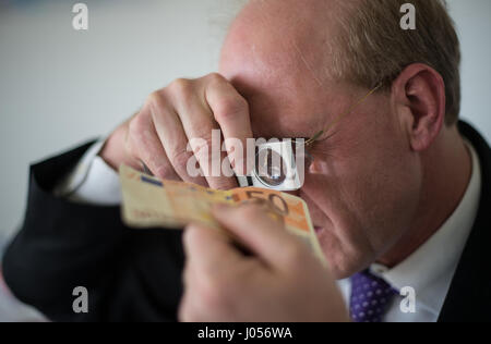 Mainz, Allemagne. 30Th Mar, 2017. Rainer l'orme, le chef du centre d'analyse de la contrefaçon de la banque fédérale allemande inspecte les deux 50 euro note avec un magnyfying glass à Mainz, Allemagne, 30 mars 2017. La Banque fédérale allemande a un centre de l'analyse de la contrefaçon qui est situé au siège de l'institution, à Mayence. Photo : Andreas Arnold/dpa/Alamy Live News Banque D'Images