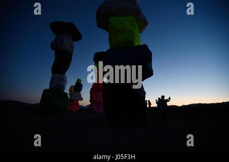 Jean, Nevada, USA. 10 avr, 2017. Photographie les gens au coucher du soleil l'art public à grande échelle installation intitulée sept Montagne magique" par l'artiste suisse Ugo Rondinone April 10, 2017 près de Jean, Nevada. L'œuvre, composée de sept tours de couleurs, de rochers empilés debout plus de trente pieds de haut, est programmé pour être affiché jusqu'en mai 2018. Crédit : David Becker/ZUMA/Alamy Fil Live News Banque D'Images