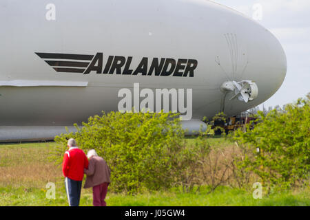 Cardington, Bedfordshire, Royaume-Uni. Apr 11, 2017. L'HYBRIDE Véhicules Air Airlander 10 est amarré à son nouveau mât d'amarrage (MMM), un véhicule à chenilles et mât d'amarrage, ce qui rend plus facile à contrôler et à "repousser" l'Airlander lorsqu'il manoeuvre autour de l'aérodrome. L'aéronef est due pour commencer c'est 2017 Programme d'essais en vol de ce mois. Les spectateurs et les photographes attendre en prévision du premier vol. Crédit photo : Mick Flynn/Alamy Live News Banque D'Images