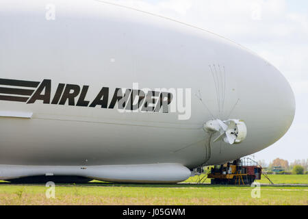 Cardington, Bedfordshire, Royaume-Uni. Apr 11, 2017. L'HYBRIDE Véhicules Air Airlander 10 est amarré à son nouveau mât d'amarrage (MMM), un véhicule à chenilles et mât d'amarrage, ce qui rend plus facile à contrôler et à "repousser" l'Airlander lorsqu'il manoeuvre autour de l'aérodrome. L'aéronef est due pour commencer c'est 2017 Programme d'essais en vol de ce mois. Un système d'atterrissage auxiliaire (ALS) a été ajouté qui permet à l'avion à atterrir en toute sécurité à une plus grande variété d'angles d'atterrissage. Crédit photo : Mick Flynn/Alamy Live News Banque D'Images