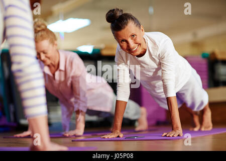 Happy woman doing push-ups sur mat Banque D'Images