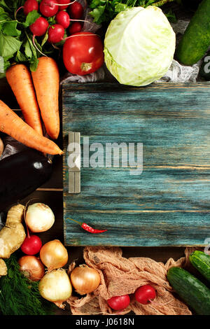 La composition fait frontière avec légumes frais sur table rustique en bois avec bac bleu vintage vue d'en haut, l'espace pour le texte. Les aubergines, chou, carotte, à Banque D'Images