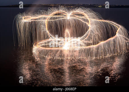 PLATEAU CENTRAL brésilien, BRÉSIL : Nature et science ont fusionné en tant que photographe utilise fireworks tirés depuis les arbres pour leur faire purger la lumière. Les photos montrent des arbres et magique un lac illuminé par la lumière-sentiers à partir de Fireworks dans divers endroits au Brésil, le Plateau Central d'un paysage riche en faune couvrant la majeure partie de l'Est, centrale et sud du Brésil. Photographe Local Vitor Schietti artifice agité manuellement avec l'aide d'une longue tige pour créer les modèles en couches et tourbillonnant jusqu'à douze photographies d'atteindre la finale la collection de photos est appelée 'Impermanent Banque D'Images