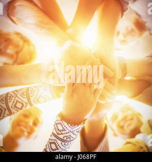 Directement au-dessous de la photo de smiling business people stacking hands in office Banque D'Images