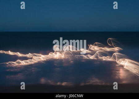 PLATEAU CENTRAL brésilien, BRÉSIL : feu d'artifice ont été utilisées pour créer des œuvres d'art uniques représentant la nature transitoire de la vie. La série nommée 'entités' montre orange-feu tourbillons et de veines superposées contre nature. Motifs de lumière peut être vu à la danse sur l'eau, de roches et de sable ainsi que de vieux arbres majestueux dans un affichage spectaculaire. Le photographe brésilien Vitor Schietti (30) a créé cette plage éclairante d'art, dans son pays d'origine en utilisant le Plateau Central brésilien comme sa toile de fond. Banque D'Images