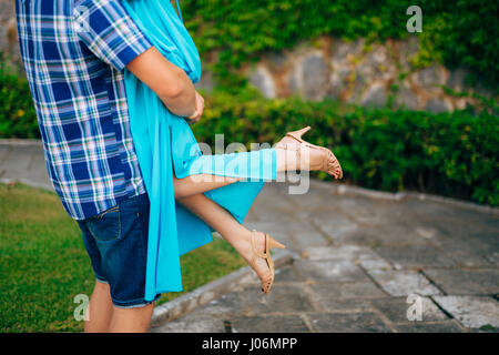 Le marié a levé la mariée dans ses bras. Les jambes de près. Mariage dans le Monténégro. Banque D'Images