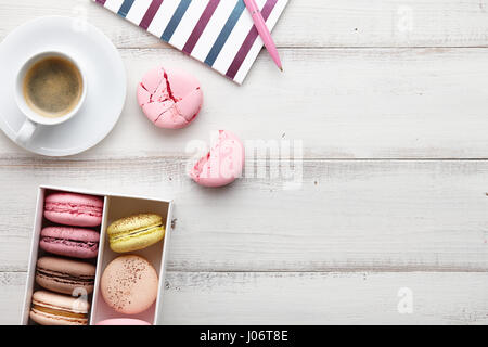 Espace de travail féminin avec café et macarons Banque D'Images