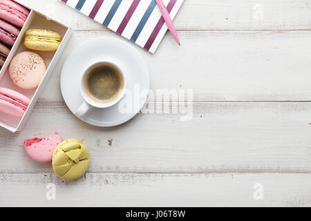 Espace de travail féminin avec café et macarons Banque D'Images