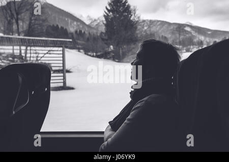 Femme sur le bus de tourisme équestre à travers la montagne, paysage d'hiver image noir et blanc monochromatique Banque D'Images