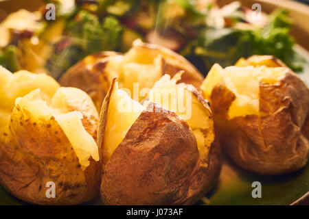 Hot buttered jacket des pommes de terre au close up avec de la vapeur Banque D'Images