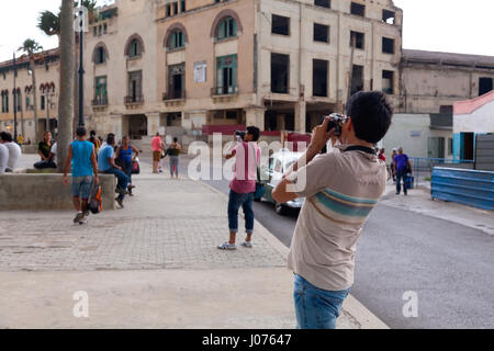 Les touristes de prendre des photos le long du Malecon dans la Vieille Havane, Cuba. Banque D'Images