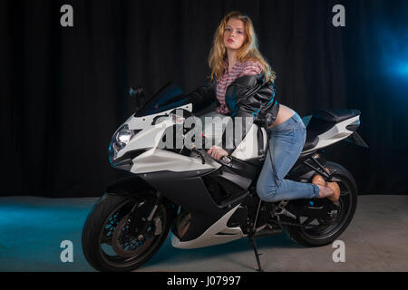 Jeune femme sur la moto.le tournage en studio. Banque D'Images