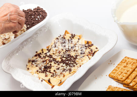 La préparation des desserts Napoléon : l'ajout de chocolat et les noix Banque D'Images