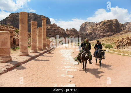 Ride hommes bédouins ânes thier par la rue Colonnade dans la ville antique de Petra. Banque D'Images