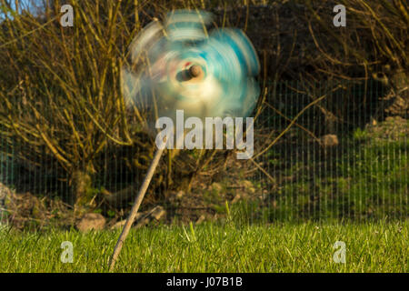 La roue crantée sur motion soufflé par le vent sur un jardin vert Banque D'Images