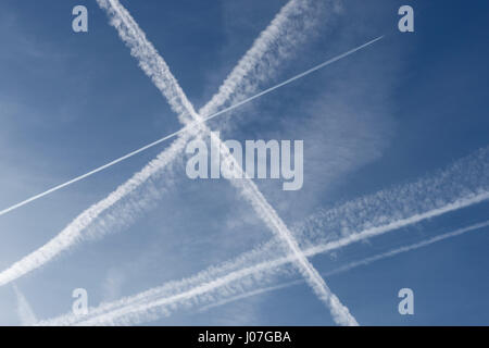 Des traînées de vapeur de l'avion dans un ciel bleu profond Banque D'Images