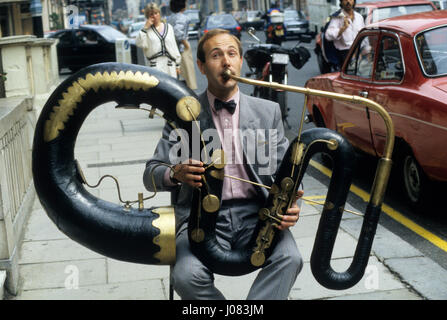 Serpent professionnel dvd Andrew van der Beek jouant "l'Anaconda" à l'extérieur de Sotheby's à Londres, août 1986. L'instrument est le seul exemple d'origine d'une contre-basse serpent faites par les frères, Joseph et Richard Bois de la région de Heaton, Yorkshire, vers 1840. Banque D'Images