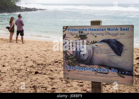 Les touristes se tiennent près de la protéger d'un Phoque moine Hawaiien signe, Ke'e Beach, Kauai, Hawaii, USA Banque D'Images