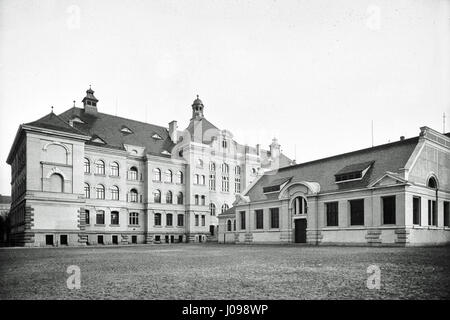 Cette image représente une vue arrière d'un bâtiment avec un gymnase, identifié comme Turnhalle F 8499, créé en 2005. La structure architecturale se concentre sur la conception fonctionnelle, avec un accent clair sur les espaces sportifs et d'éducation physique. Les éléments de conception sont modernes et pratiques, reflétant l'accent mis par l'époque sur l'efficacité et l'utilité polyvalente dans les bâtiments publics. Banque D'Images