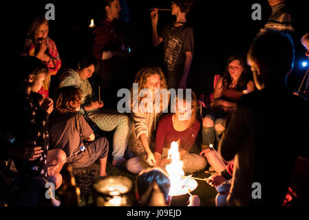 Griller des guimauves sur bois enfants autour d'un feu tandis que l'écart camping Banque D'Images