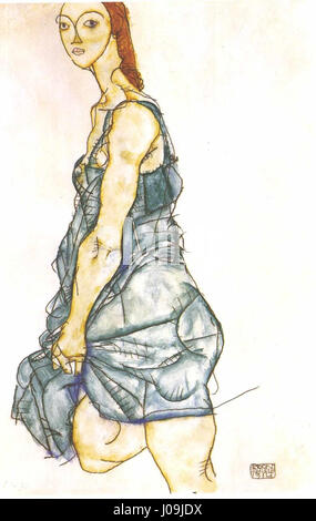 L'œuvre de 1914 d'Egon Schiele, Stehende Frau in grünem Hemd, met en scène une femme debout vêtue d'une chemise verte. Connu pour son style expressionniste, l'utilisation de formes déformées et d'intensité émotionnelle par Schiele est évidente dans cette pièce. Banque D'Images