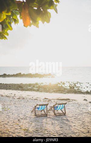 Deux chaises de plage face à la mer avec vue sur le coucher de soleil Banque D'Images