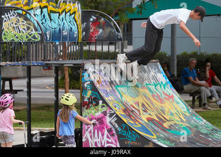 Young Asian man skateboarding dans le scape skate park, à Singapour. Banque D'Images