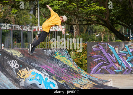 Jeune homme la planche à roulettes dans le SCAPE Skate Park, Singapour. Banque D'Images