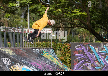 Young Caucasian Man Skateboarding dans le SCAPE Skate Park, à Singapour. Banque D'Images