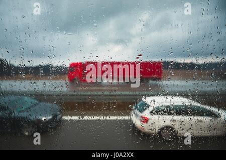 Plan rapproché sur les gouttes. Le trafic sur l'autoroute sous la pluie. Banque D'Images