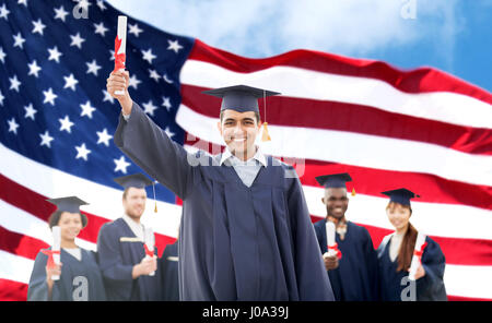 Les élèves heureux dans mortarboards avec diplômes Banque D'Images