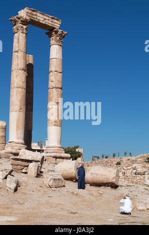 Les hommes musulmans devant les ruines du temple d'Hercule, la plus importante structure romaine dans la citadelle d'Amman, le site archéologique Banque D'Images