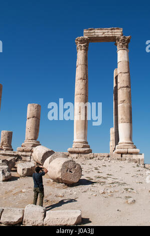 Un homme à prendre des photos des ruines du temple d'Hercule, la plus importante structure romaine dans la citadelle d'Amman, le site archéologique Banque D'Images