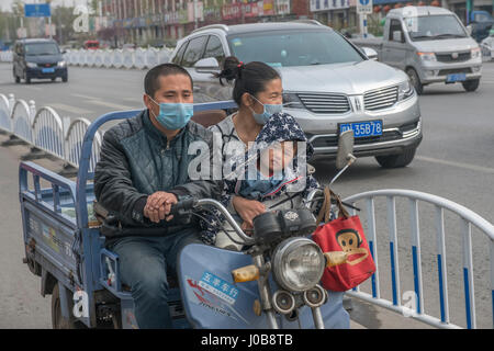 Famille chinoise de trois sur trois roues en Xiong County, province de Hebei, Chine. 09-Apr-2017 Banque D'Images