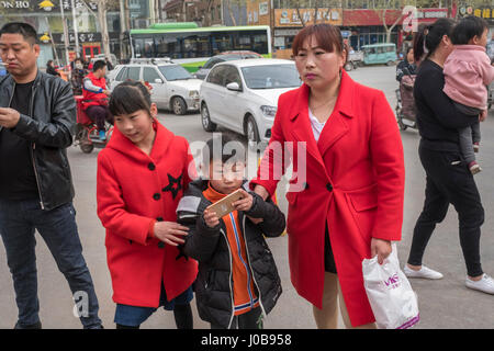 Une mère de deux enfants, une fille et un garçon, dans le comté de Xiong, province de Hebei, Chine. 09-Apr-2017 Banque D'Images