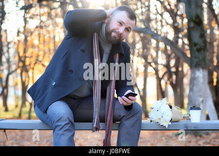 L'homme en attente sur un banc la date in autumn park Banque D'Images