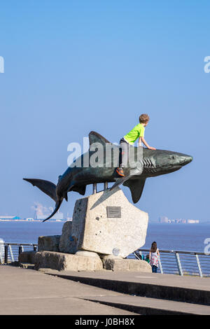 Petit garçon assis sur "requin", sculpture en bronze de requins gris de récif par Christopher Kelly, 2002, l'aquarium The Deep, Kingston-upon-Hull, Yorkshire, Angleterre Banque D'Images