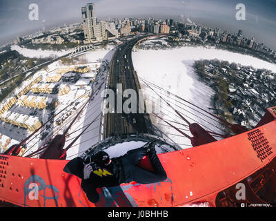 Moscou, Russie : regardez comme une excalibur monte le plus haut pont à haubans d'Europe et atteint le sommet à 344 mètres sans aucun équipement de sécurité. Les images et la vidéo montrent le grimpeur audacieux jusqu'dart les poutres en acier et les câbles avant d'atteindre un escalier ouvert et l'échelle. D'autres superbes clichés montrent l'Adrenaline Junkie triomphant posant en haut de la structure comme il est assis sur un rebord haut au-dessus de l'autoroute et des voitures qui passent au-dessous. Les images spectaculaires et des images ont été prises à Zhivopisnyy Bridge à Moscou, Russie par les photographe extrême et blogueur Alex Nomer Banque D'Images