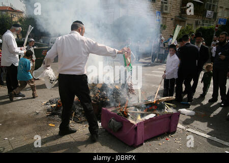 Les hommes juifs orthodoxes brûler Hamets, du pain et des aliments, pas casher pour Pâque, le matin de la veille de la maison de vacances ici, un homme se jette dans des hot-dogs. Banque D'Images