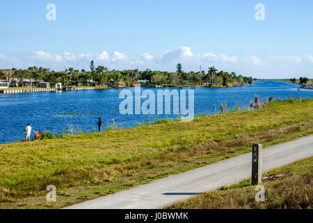 Florida Lake Okeechobee,canal,sentier pittoresque,parc,sentier,adulte homme hommes,femme femme femme femme,chien chiens,pêche,front de mer,visiteur voyage tra Banque D'Images