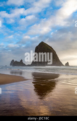 Haystack Rock réfléchi sur le rivage à Cannon Beach sur la côte nord-ouest du Pacifique, de l'Oregon, USA Banque D'Images