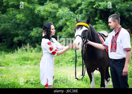 Couple in Ukrainian costumes avec un cheval Banque D'Images