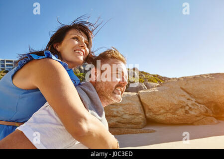 Man carrying woman on Beach, Cape Town, Afrique du Sud Banque D'Images