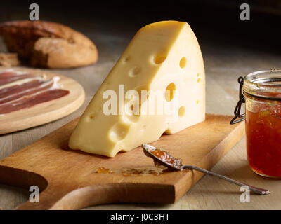 Still Life de fromage Edam avec chutney de coing, sur planche à découper Banque D'Images