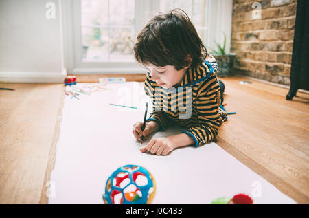 Boy lying on floor dimensions sur du papier long Banque D'Images